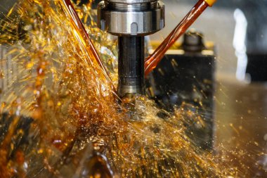 CNC değirmen makinesinin yağ soğutma metoduyla küf parçalarını kestiği yakın çekim sahnesi. CNC makine merkezi tarafından üretilen kalıp ve ölüm süreci.