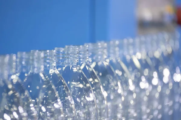 The PET bottles  on the conveyor belt for filling process in the drinking water factory. The hi-technology of plastic bottle manufacturing process.