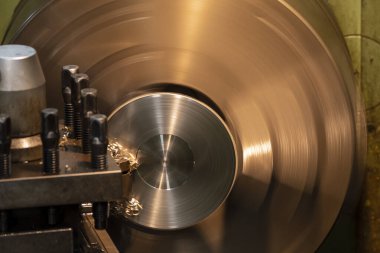 Torna makinesi, kesme aletleriyle metal parçaları kesiyor. Makineyi döndürerek metal işleme süreci.