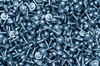 Açık mavi sahnede çamaşır makinesinin kafası vidalanmış. Özel vida parçaları üretim konsepti.