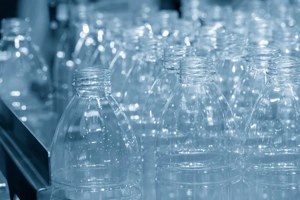 The PET bottles  on the conveyor belt for filling process in the drinking water factory. The hi-technology of plastic bottle manufacturing process.