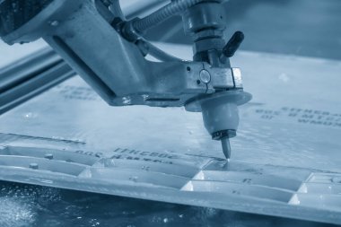 Çok eksenli yıpratıcı su püskürtme makinesi metal plakayı kesiyor. Çok eksenli su jeti kesme makinesi ile yüksek teknolojili metal kesme işlemi .