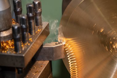 Torna makinesi, kesme aletleriyle metal parçaları kesiyor. Makineyi döndürerek metal işleme süreci.