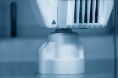 Açık mavi sahnede 3D yazıcı operasyonunun yakın çekim sahnesi. 3D yazıcının hızlı prototip üretim süreci.