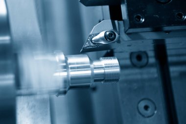 CNC torna makinesi vida metal şaft parçalarını kesiyor. CNC dönüşüm makinesinin yüksek teknolojili metal işlemesi .
