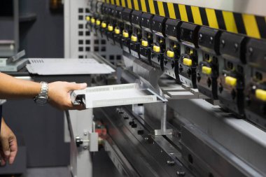 Hidrolik fren bükme makinesiyle çalışan teknisyen. Yetenek operatörünün kullandığı levha metal çalışması.