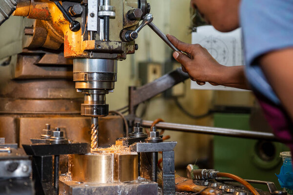 The operation of NC milling machine by technician operator. The shop floor operation by NC milling machine.