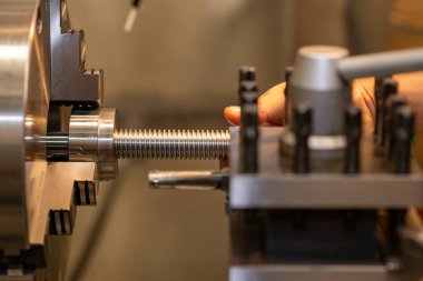Makineyi döndürme işlemi top vidalarını kesme kısmı. Torna makinesinin çalışması metal şaftı kayganlaştırıcı soğutma metoduyla kesiyor.. 
