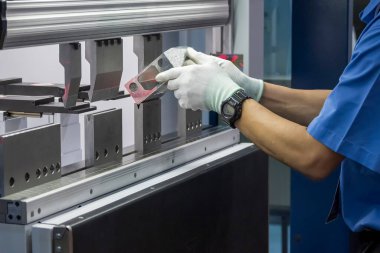Hidrolik fren bükme makinesiyle çalışan teknisyen. Yetenek operatörünün kullandığı levha metal çalışması.