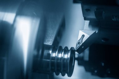 CNC torna makinesi makara parçalarını kesiyor. CNC dönüşüm makinesinin yüksek teknolojili metal işlemesi .