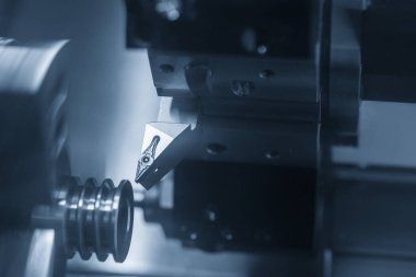 CNC torna makinesi makara parçalarını kesiyor. CNC dönüşüm makinesinin yüksek teknolojili metal işlemesi .