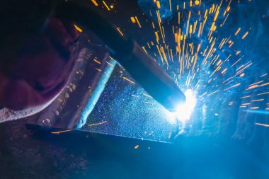 Elektrik kaynaklama işleminin yakın çekim sahnesi. İnşaat alanındaki kaynak operasyonu.. 