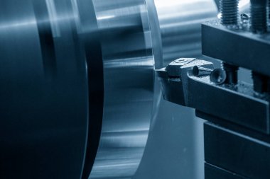 Taretle tutturulan torna kesme aletinin çip yerleştirildiği yakın çekim sahnesi. Makineyi döndürerek metal işleme süreci.