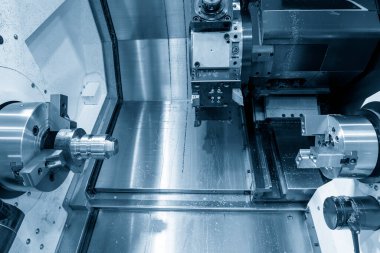 Çift taretli CNC torna makinesi metal şaft parçalarını kesiyor. CNC dönüşüm makinesinin yüksek teknolojili metal işlemesi .