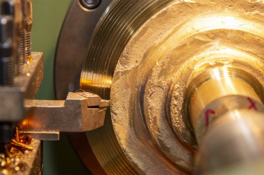 Torna makinesi, aletleri keserek pirinç parçaları keserek çalışıyor. Makineyi döndürerek metal işleme süreci.