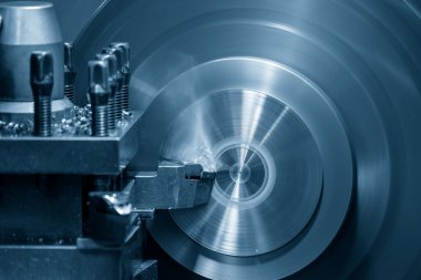 Torna makinesi, torna tezgahlarıyla metal parçaları keserek çalışıyor. Makineyi döndürerek metal işleme süreci.