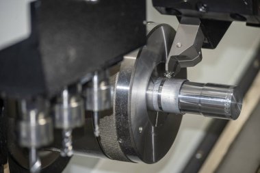 CNC torna makinesi metal şaft parçalarını kesiyor. CNC dönüşüm makinesinin yüksek teknolojili metal işlemesi .