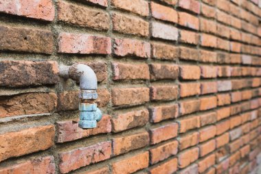 Old water pipe with the brick wall