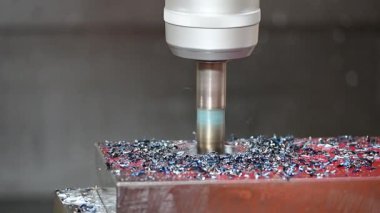 CNC değirmen makinesi, indekslenebilir araçla sert maddi parçaları kesiyor. CNC değirmen makinesi deliği metal plakayı kesiyor..