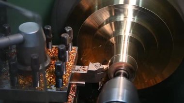 Torna makinesinin bitirdiği sahne pirinç maddi parçaları kesiyor. Makineyi döndürerek metal işleme süreci.