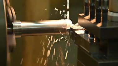 Torna makinesi ağır çekim sahnesi metal şaft parçalarını sıvı soğutucu metoduyla kesiyor. Makineyi döndürerek metal işleme süreci.