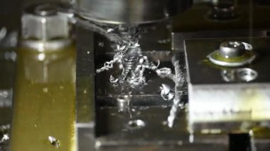 Torna makinesi ağır çekim sahnesi metal şaft parçalarını sıvı soğutucu metoduyla kesiyor. Makineyi döndürerek metal işleme süreci.