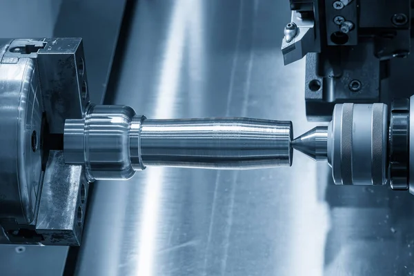 The operation CNC lathe machine finish cut the metal shaft parts in the light blue scene. The surface finishing process by turning machine. 