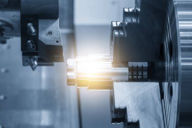 Sahneyi kapat CNC torna makinesi mavi ton sahnesindeki metal şaft parçalarını ışık efektiyle kesti. CNC dönüşüm makinesi tarafından çalışan yüksek teknolojili metal işleme .