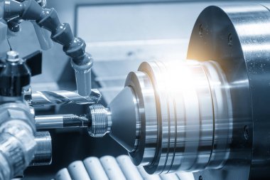 Olay yerini kapatıyoruz. CNC çok görevli torna makinesi İsviçre tipi delik delme işlemi açık mavi sahnede pirinç bağlantı parçaları. CNC dönüşüm makinesinin yüksek teknolojili metal işlemesi.