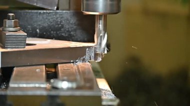 Yavaş çekim sahnesi değirmen işlemini NC değirmen makinesinin metal plaka parçalarını düz burun değirmeni aletleriyle öğütür. Değirmen makinesindeki metal çalışma konsepti..