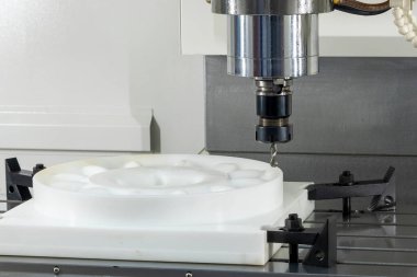 CNC değirmen makinesi sert bir top burun değirmeni kullanarak naylon parçaları kesiyor. Polimer bileşenler için hassas plastik mekanizma süreci, endüstriyel imalat, mühendislik teknolojisi ve metal olmayan modern CNC mekanizmasını temsil etmektedir.