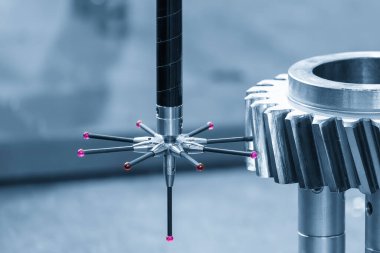 Açık mavi endüstriyel ortamda metal dişli parçalarını ölçen modüler bir sonda ile donatılmış CMM makinesi. Gelişmiş metroloji teknolojisini temsil eden bir koordinat ölçüm makinesi kullanarak hassas boyut teftişi ve kalite kontrol süreci