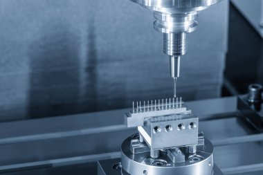 CNC değirmen makinesi bakır elektrot parçaları üzerinde hassas bir kesim gerçekleştiriyor. Kontrollü açık mavi endüstriyel ortamda sert bir top burun değirmeni aleti kullanıyor. Bu işlemler genellikle EDM elektrot imalatında uygulanır.