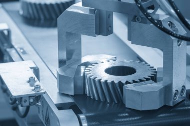 Otomatik malzeme işleme süreci yüksek hassasiyetli endüstriyel robotik kol kullanarak otomotiv vites parçalarını alıp hareket ettirir..