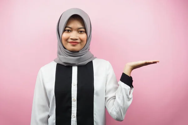 空の空間の方向に何かを示し 提示し 手で美しい若いアジアのイスラム教徒の女性 自信を持って笑顔 興奮して カメラに直面して ピンクの背景に孤立 広告コンセプト — ストック写真