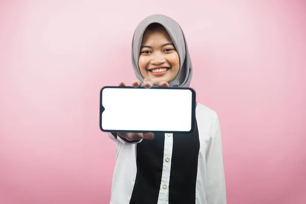 自信を持って笑顔美しい若いアジアのイスラム教徒の女性 スマートフォンを手で熱狂的かつ陽気な アプリケーションを提示 ゲームを提示 ピンクの背景に孤立 広告コンセプト — ストック写真