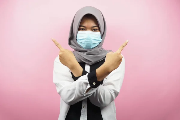 戴着医疗面具的穆斯林妇女 手指空旷的空间 手指着展示的东西 被粉色背景隔离 — 图库照片