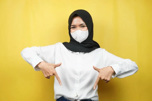 穆斯林妇女戴着白色面具 双手朝下 展示了一些东西 点击下面的链接 展示了被黄色背景隔离的产品 — 图库照片