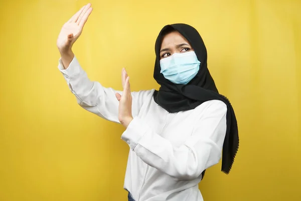 穆斯林妇女戴着医疗面罩 手拒绝某样东西 手停止某样东西 手不喜欢某样东西 被黄色背景隔离 — 图库照片