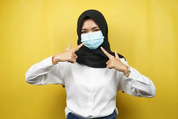 戴着医疗面罩 手持面罩的穆斯林妇女 抗日冕病毒运动 抗Covid 19运动 使用面罩的健康运动 在黄色背景下隔离 — 图库照片