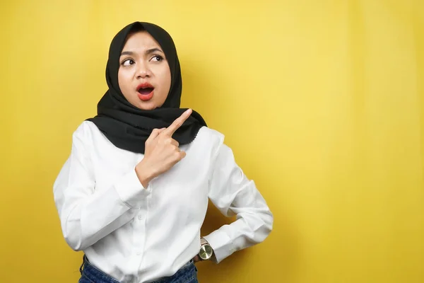美丽的年轻的亚裔穆斯林女子震惊了 惊讶了 哇的表情 手指向空旷的空间 展示了什么 展示了产品 被黄色背景隔离了 — 图库照片