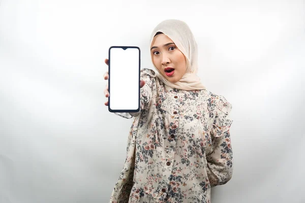 美丽的年轻的亚裔穆斯林女子震惊 手持带有白屏 空白屏幕的智能手机 推广应用程序 促销产品 展示某物 被白色背景隔离 — 图库照片