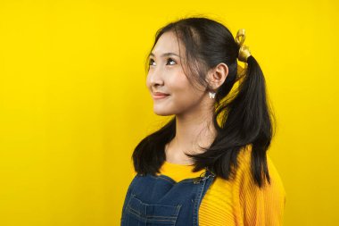 Güzel ve sevimli, neşeli genç bir kadın, boş alana bakıyor, bir şeyler sunuyor, ürünü tanıtıyor, reklamını yapıyor, izole ediyor.