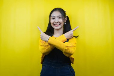 Güzel ve sevimli genç bir kadın, neşeli, kendinden emin, elleri boş yere bakıyor, bir şeyler sunuyor, ürünleri tanıtıyor, reklam yapıyor, izole ediyor.