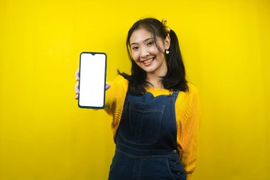 Güzel ve sevimli genç bir kadın, neşeli, kendine güvenen, akıllı telefon tutan, boş ya da beyaz ekranlı akıllı telefon, uygulamayı destekleyen, ürünü tanıtan, reklamını yapan, izole edilmiş