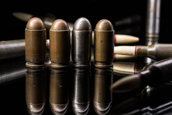 Пістолетні кулі поспіль на чорному тлі — стокове фото
