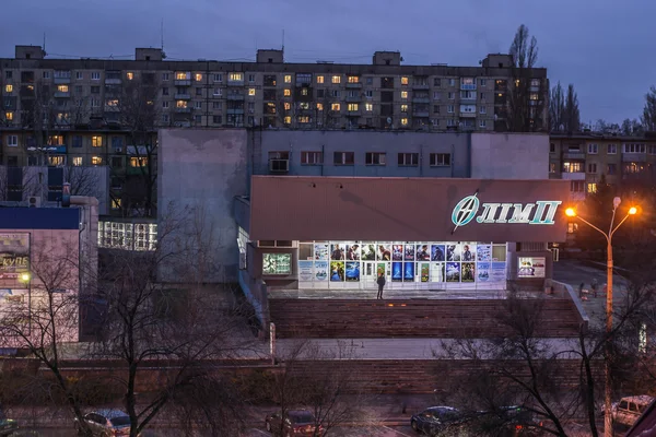 Krivoy Rog, Ukraina: 29 mars 2015. Olimp bio i skymningen med block hus — Stockfoto