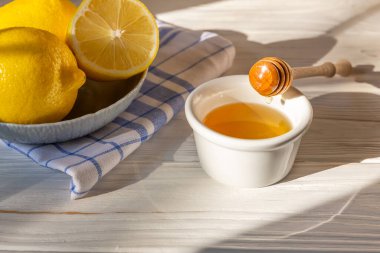 Beyaz kasede bal ya da sopa, limon ve nane arkaplan olarak mavi ve beyaz keten havlu. Organik doğal bileşenler konsepti.