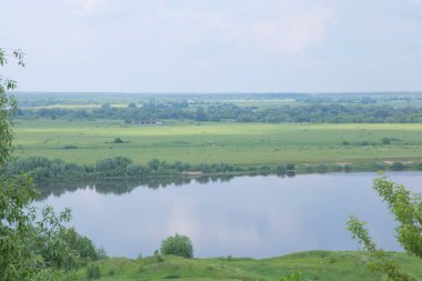 Fırtınalı bir gökyüzü ve Rusya Oka nehri ile nehir taşkın ovasının manzarası
