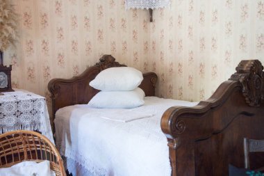 Beyaz battaniyeli eski tahta bir Viktorya yatağı.